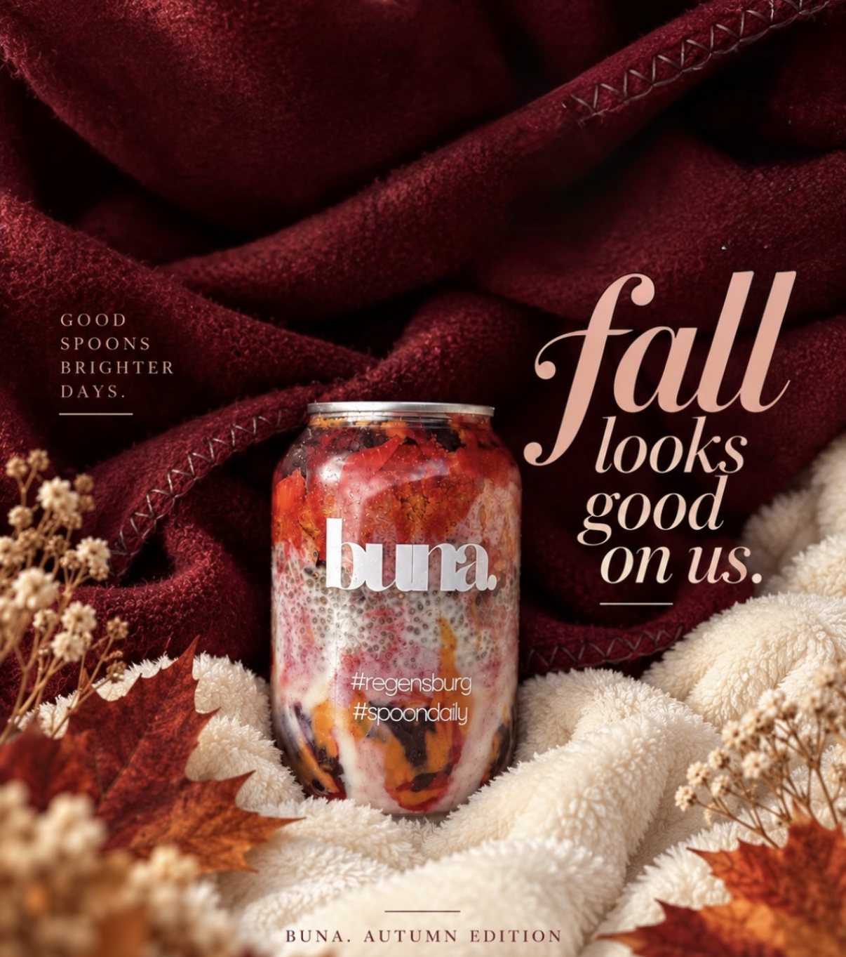 buna-Dose der Autumn Edition mit roter Füllung und Chia auf einer weinroten Decke, daneben Herbstlaub